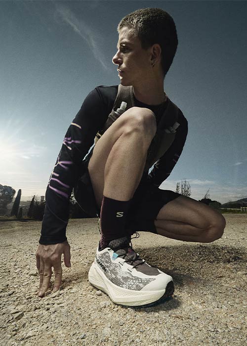 homme accroupi portant des Salomon Aero Glide 4 GRVL